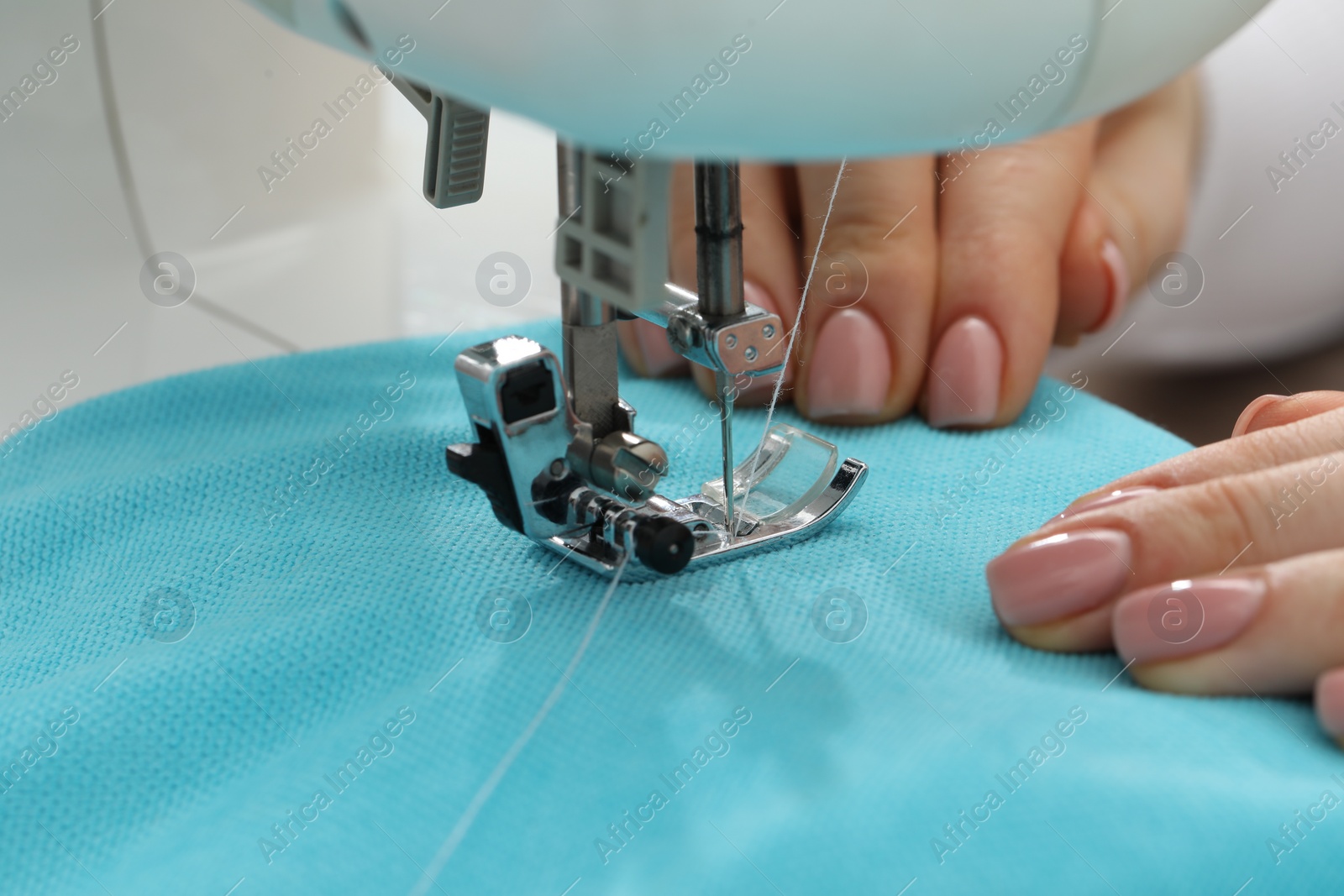 Photo of Seamstress working with sewing machine indoors, selective focus