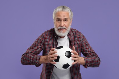 Photo of Senior sports fan with soccer ball on purple background