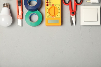 Photo of Flat lay composition with electrician's tools and space for text on gray background