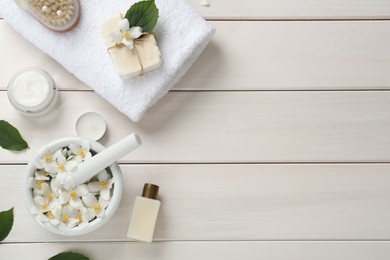 Photo of Flat lay composition with jasmine flowers and skin care products on white wooden table, space for text