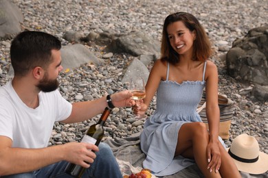 Photo of Happy young couple having picnic on beach