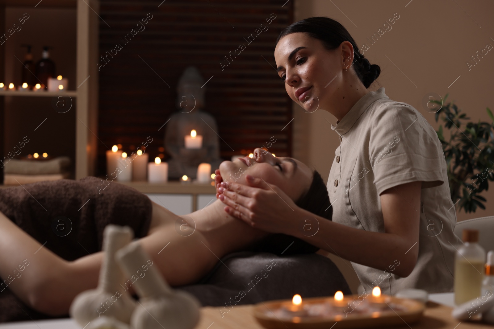 Photo of Spa therapy. Beautiful young woman lying on table during massage in salon