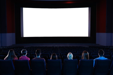 Young people watching movie in cinema theatre. Space for text