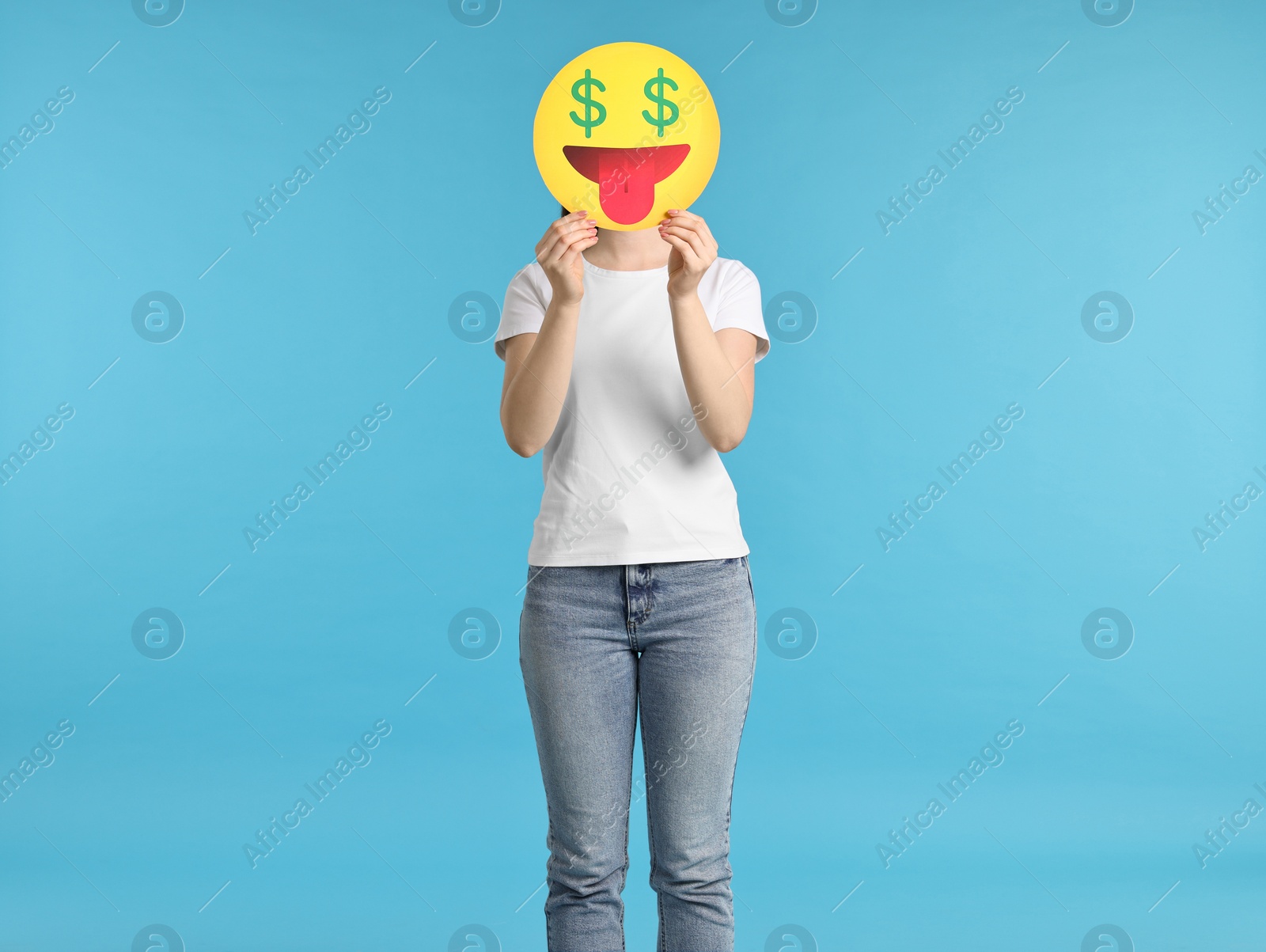 Photo of Woman covering face with dollar signs instead of eyes on light blue background
