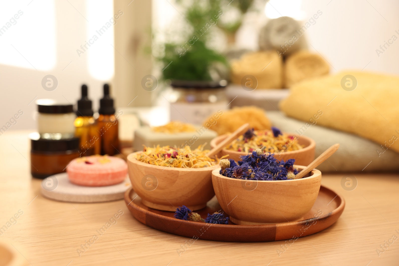 Photo of Dry flowers on wooden table indoors. Spa time