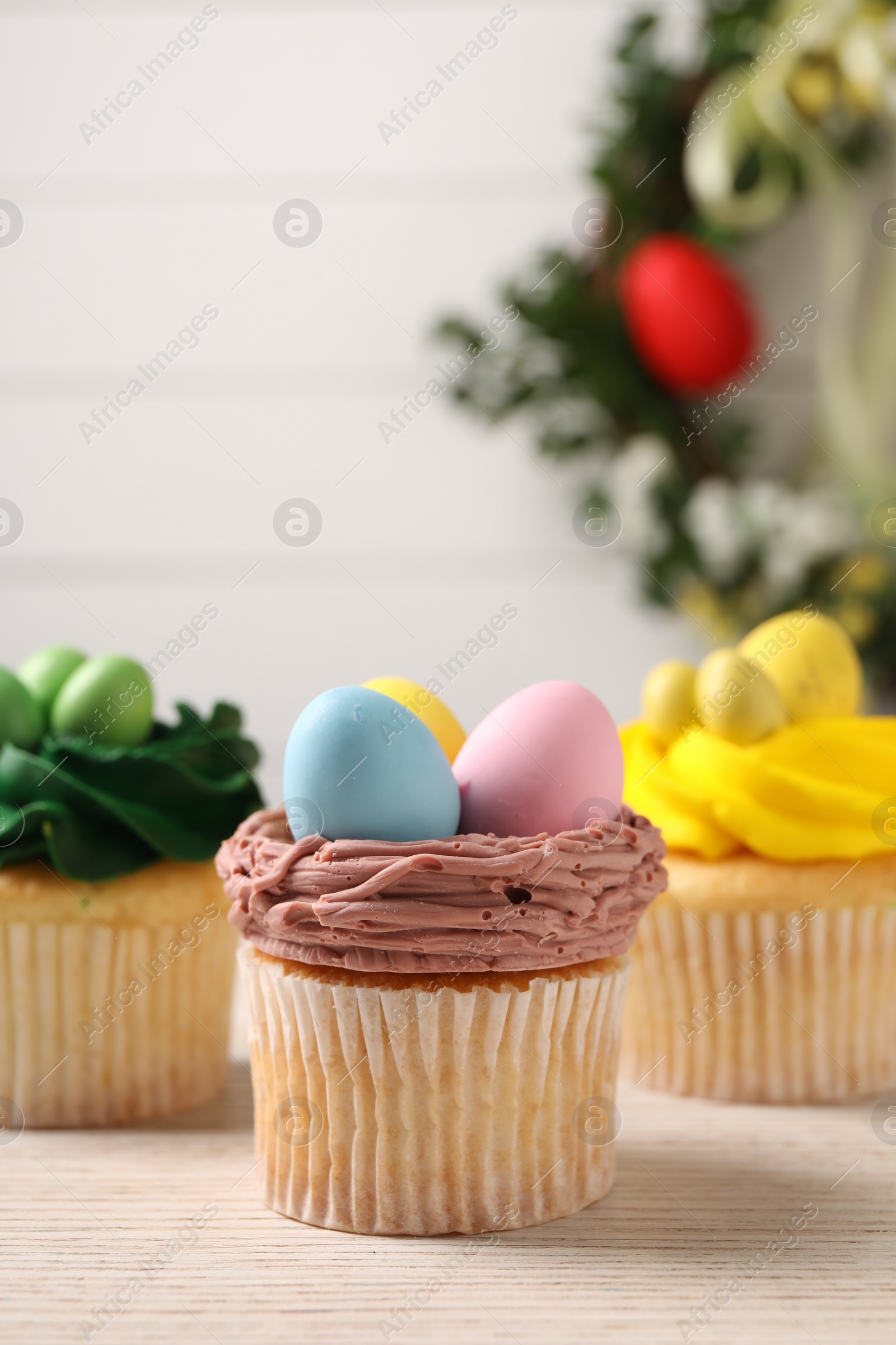 Photo of Tasty decorated Easter cupcakes on wooden table, closeup