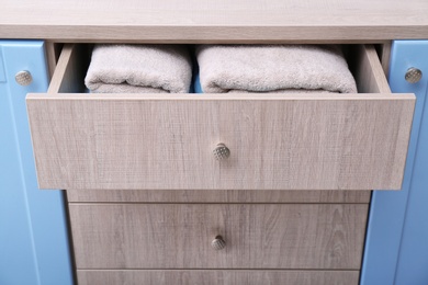 Photo of Clean towels in open drawer, closeup