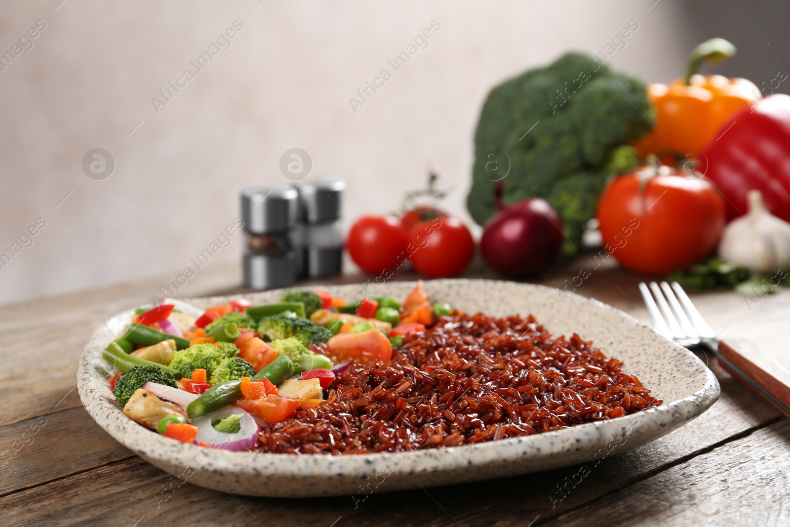 Photo of Plate with cooked brown rice on table. Space for text