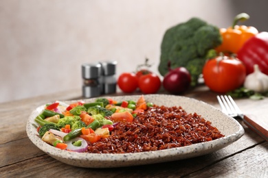 Photo of Plate with cooked brown rice on table. Space for text