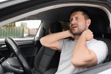 Photo of Man suffering from neck pain in car