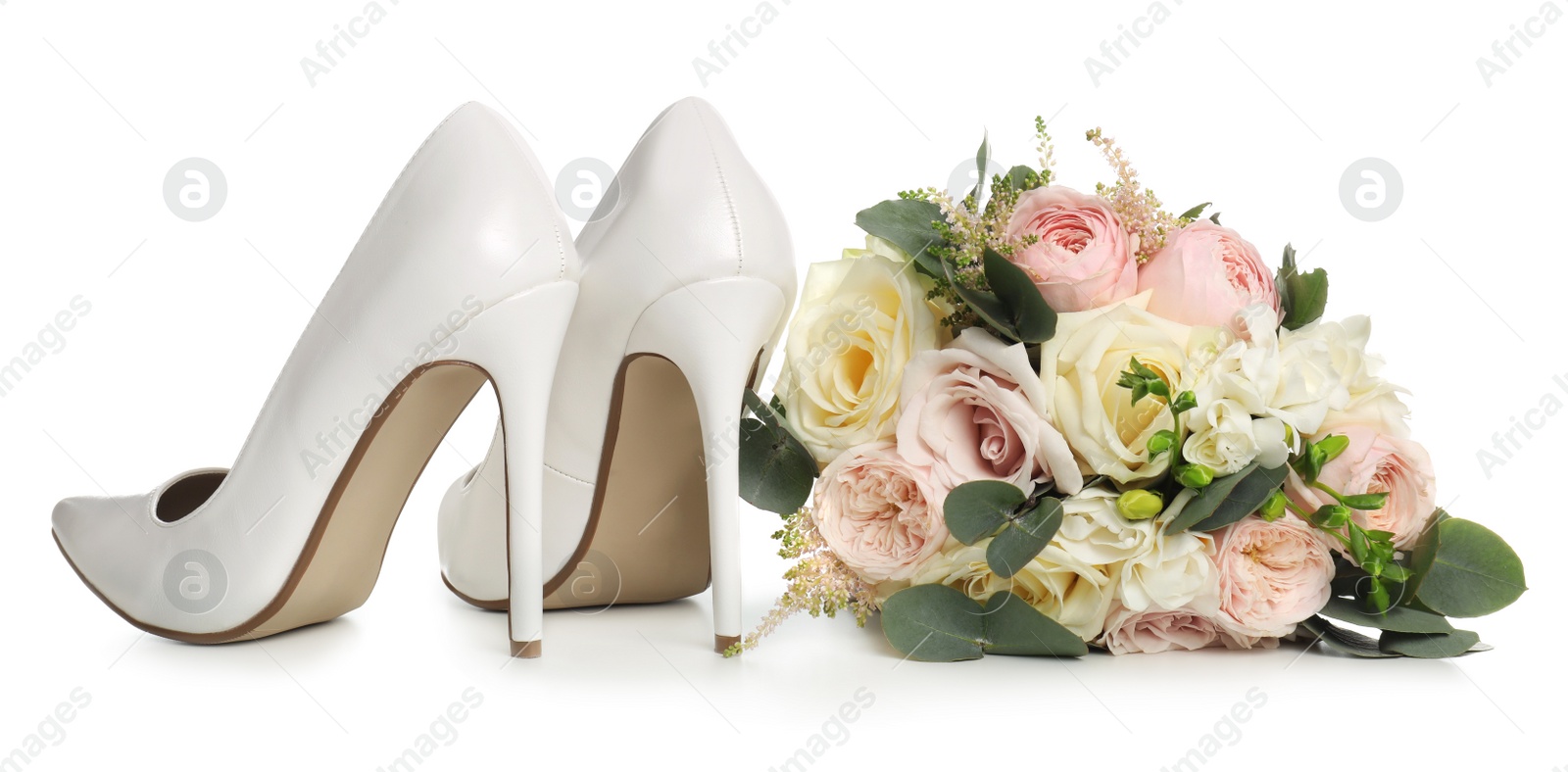 Photo of Pair of wedding high heel shoes and beautiful bouquet on white background