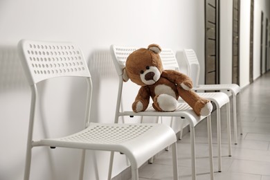 Photo of Cute lonely teddy bear on chair indoors