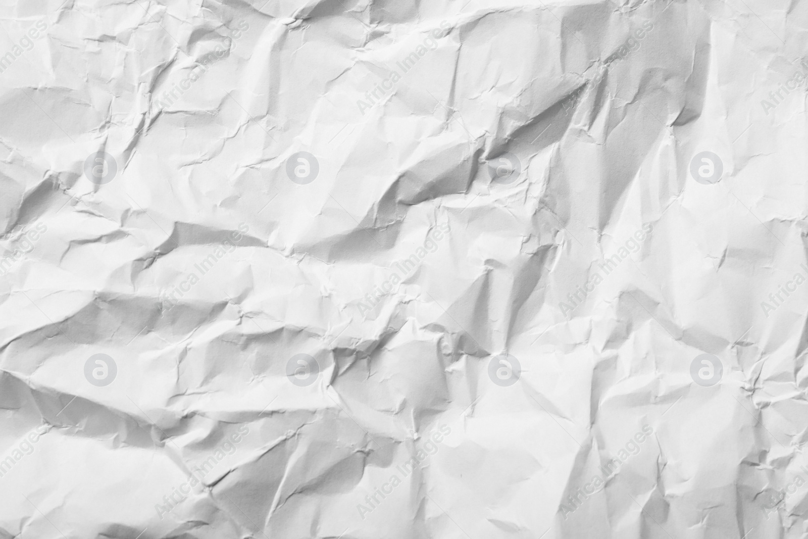 Photo of Sheet of white crumpled paper as background, closeup