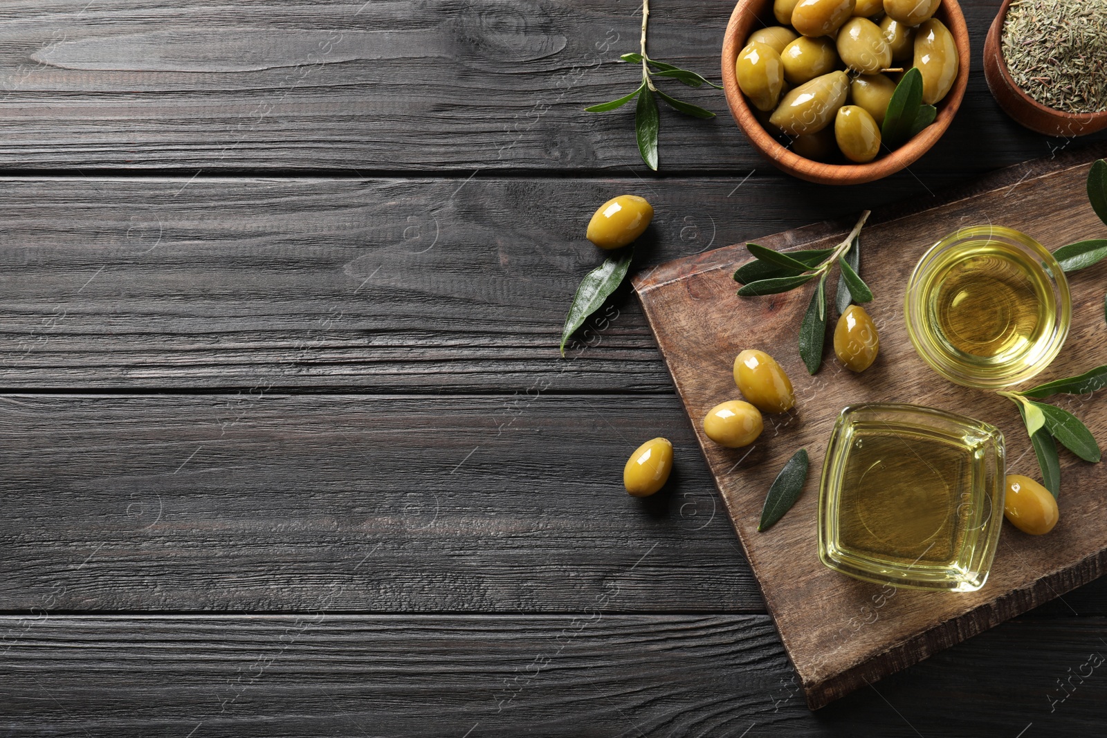 Photo of Flat lay composition with olive oil on black wooden table. Space for text