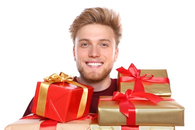 Young man with Christmas gifts on white background