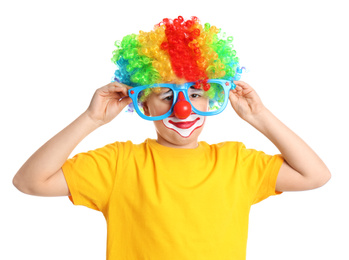 Photo of Preteen boy with clown wig and party glasses on white background. April fool's day