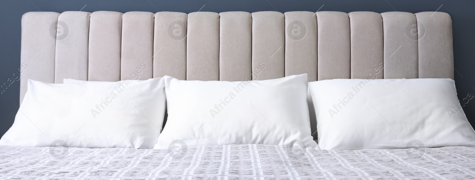 Image of White soft pillows on comfortable bed indoors. Banner design