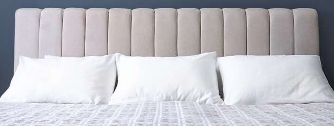 Image of White soft pillows on comfortable bed indoors. Banner design