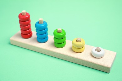 Photo of Stacking and counting game wooden pieces on green background. Educational toy for motor skills development