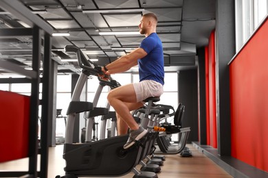 Photo of Man training on exercise bike in gym