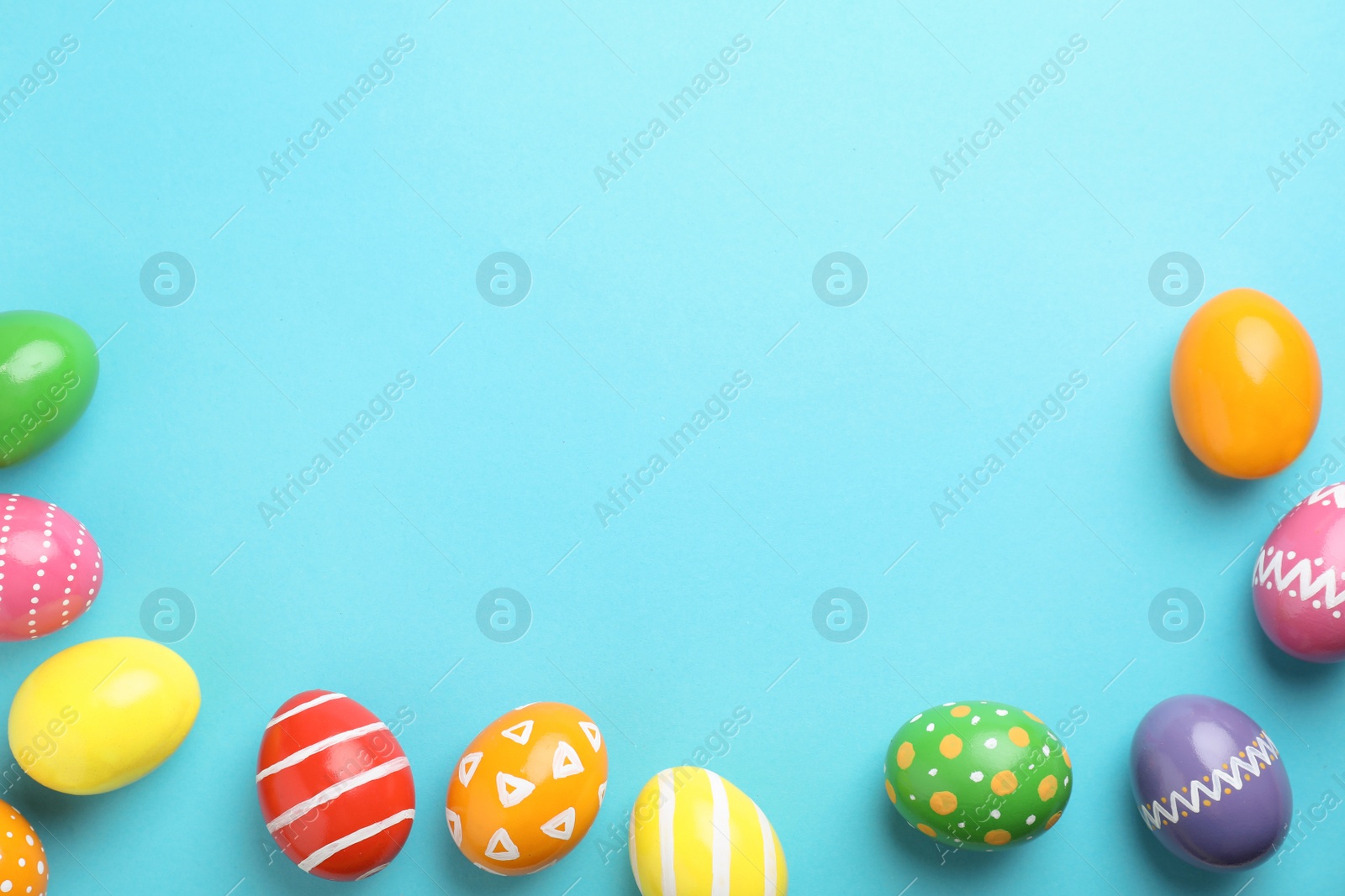 Photo of Decorated Easter eggs and space for text on color background, top view