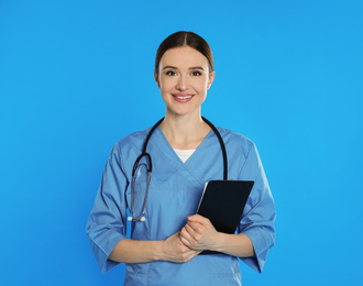 Photo of Doctor with stethoscope and clipboard on blue background