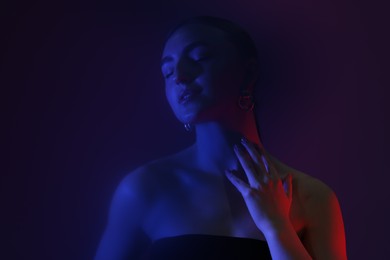 Photo of Portrait of beautiful young woman on color background in neon lights