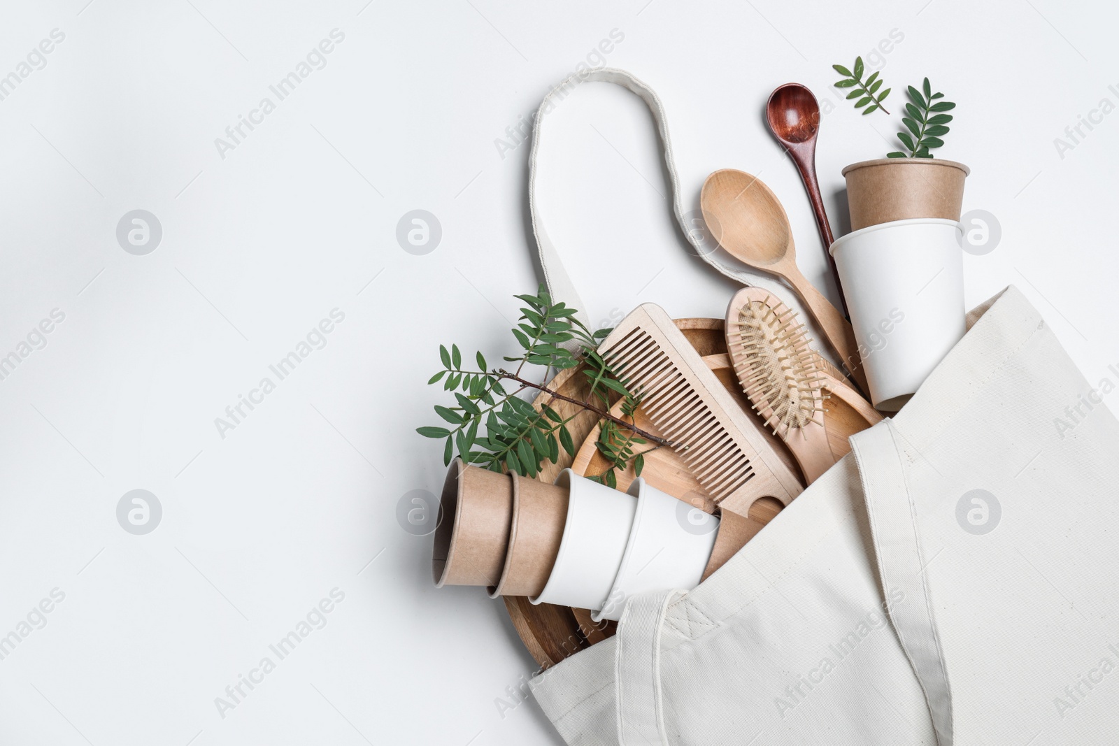 Photo of Eco bag with different disposable items on white background, top view and space for text. Recycling concept