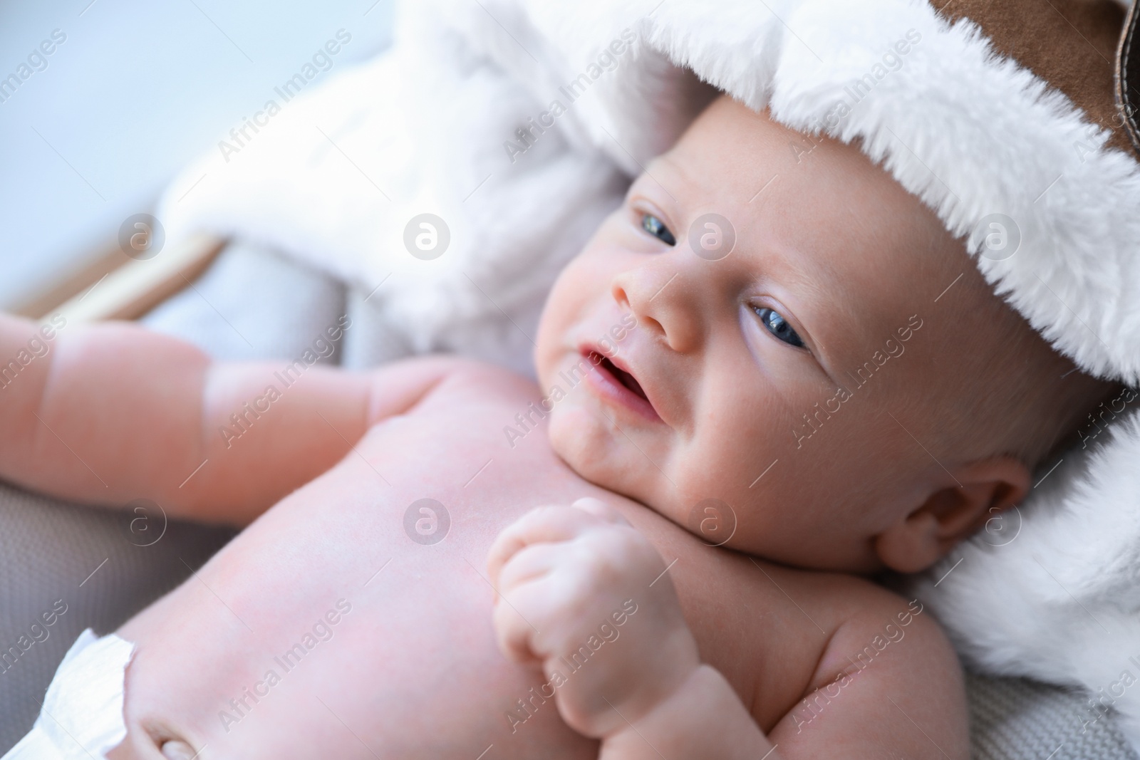 Photo of Cute newborn baby in aviator hat on blanket, closeup