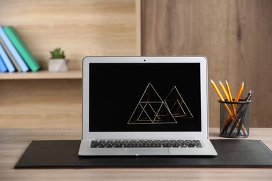 Photo of Modern laptop and office supplies on wooden table indoors