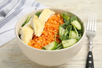 Photo of Delicious lentil bowl with soft cheese and cucumber on white wooden table