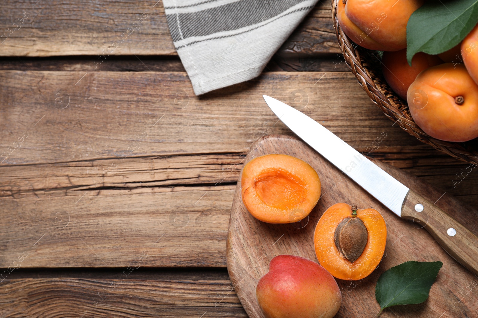 Photo of Delicious fresh ripe apricots on wooden table, flat lay. Space for text