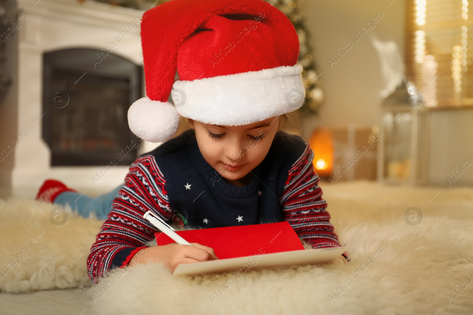 Photo of Cute child writing letter to Santa Claus at home. Christmas tradition