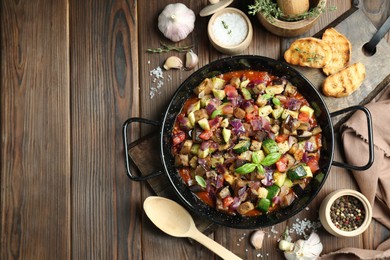Photo of Delicious ratatouille in baking dish served on wooden table, flat lay. Space for text