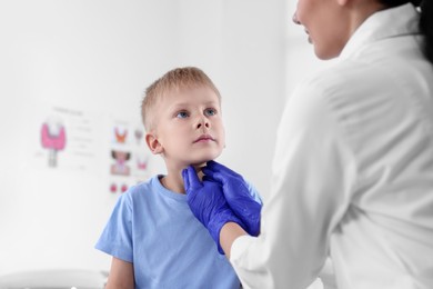 Endocrinologist examining boy's thyroid gland at hospital, closeup