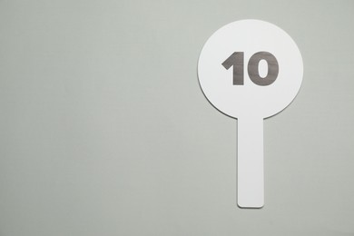 Auction paddle with number 10 on light grey background, top view. Space for text