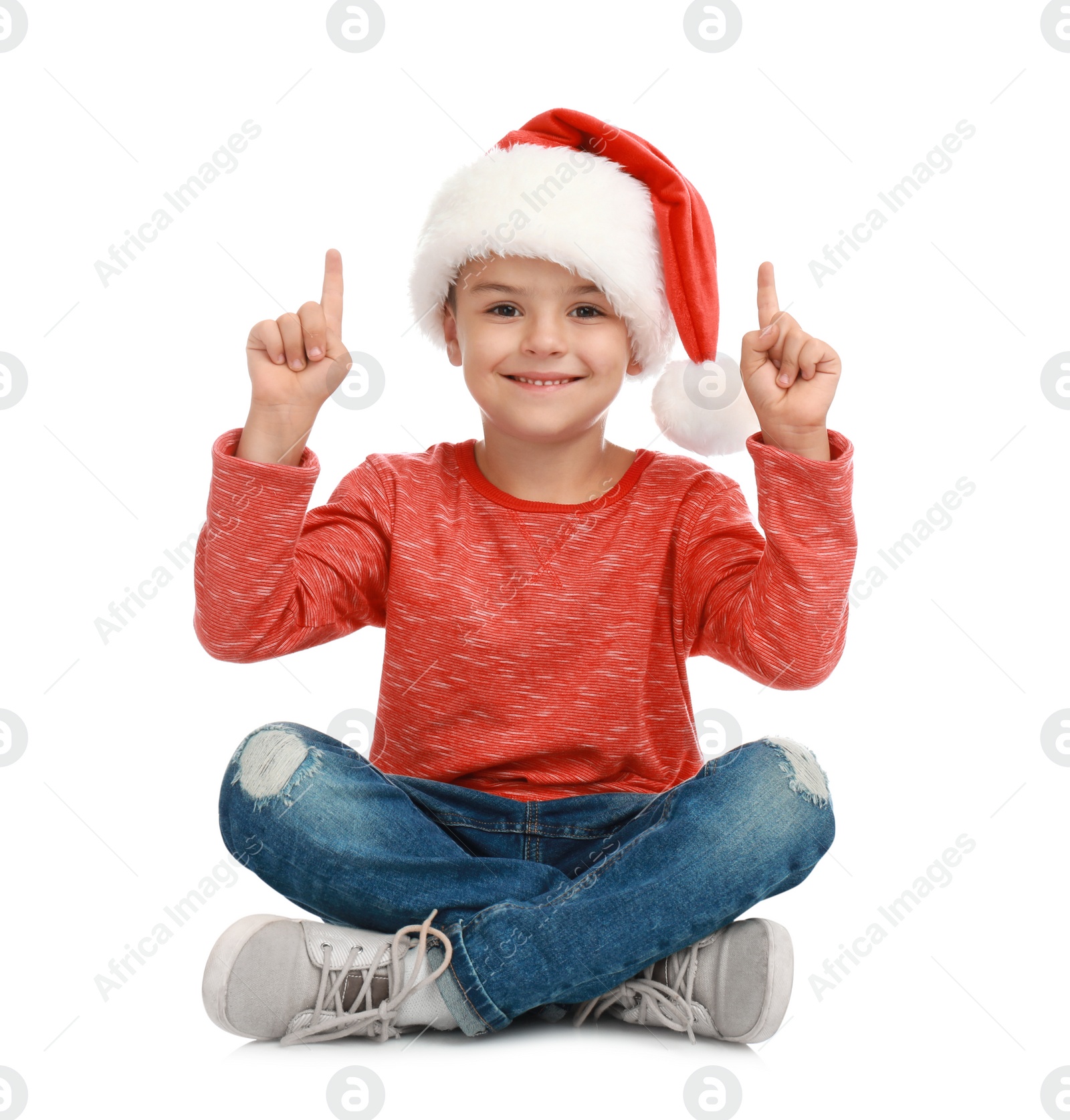 Photo of Cute little child wearing Santa hat on white background. Christmas holiday