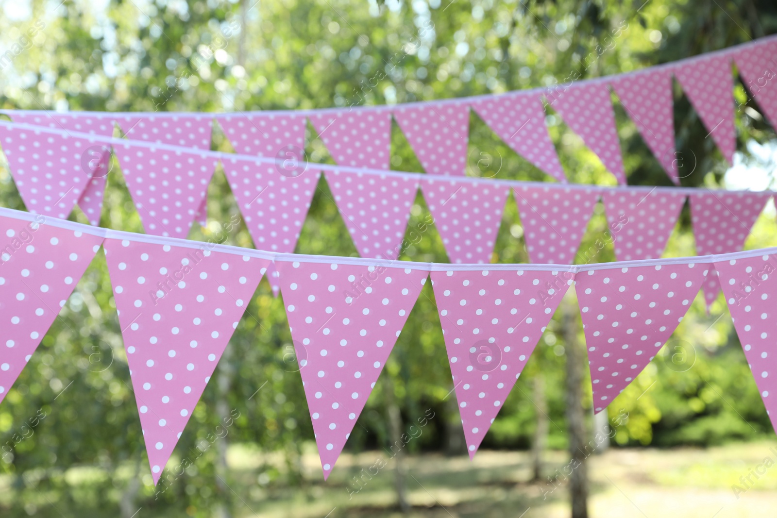 Photo of Pink bunting flags in park. Party decor