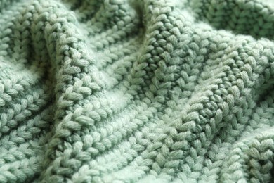 Beautiful pale green knitted fabric as background, closeup