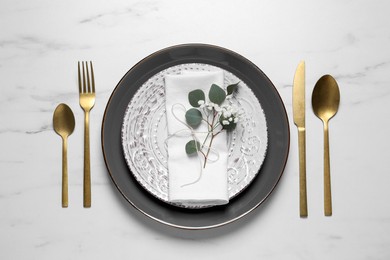 Photo of Stylish table setting with cutlery, flower and eucalyptus leaves, flat lay