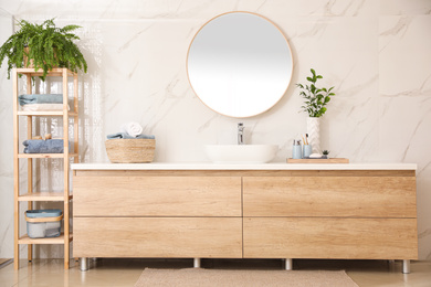 Photo of Stylish bathroom interior with countertop and mirror. Design idea