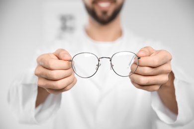 Photo of Male ophthalmologist with eyeglasses in clinic, closeup