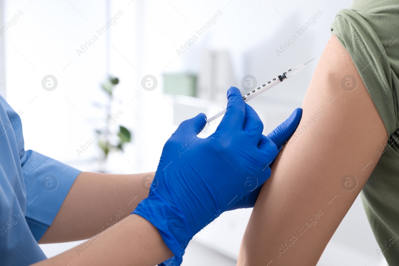 Photo of Doctor giving injection to woman in hospital, closeup. Immunization concept