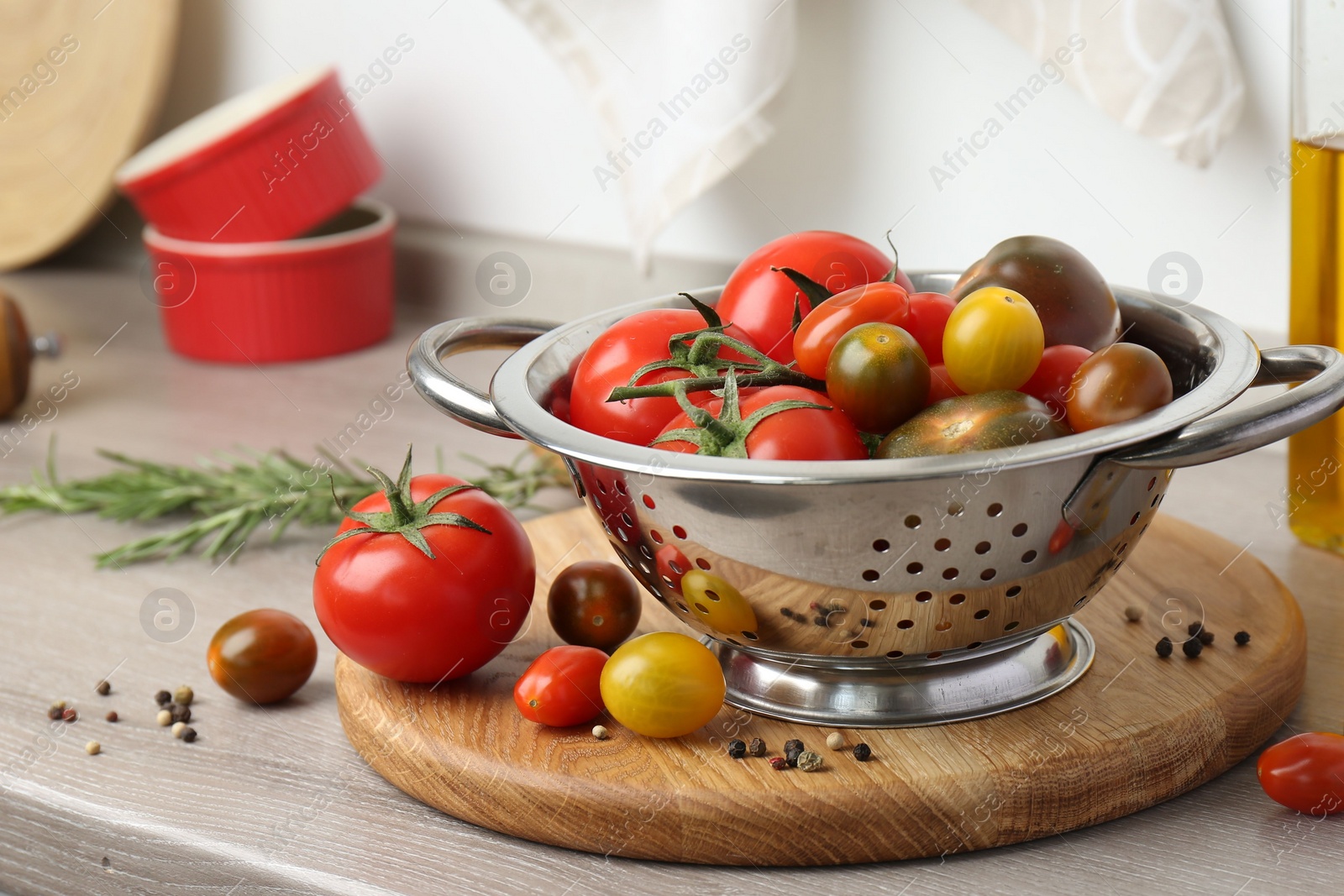 Photo of Metal colander with tomatoes on countertop in kitchen