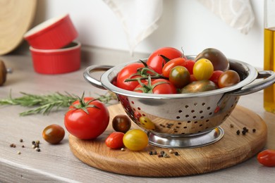 Photo of Metal colander with tomatoes on countertop in kitchen