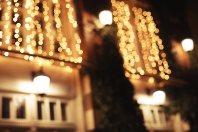 Blurred view of building with beautiful street lights at night. Bokeh effect