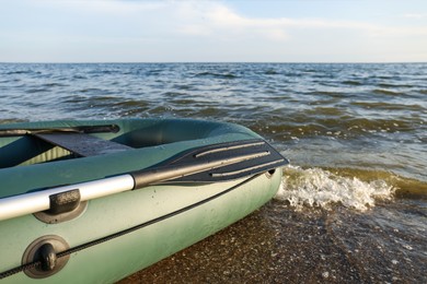 Inflatable rubber fishing boat on sandy beach near sea