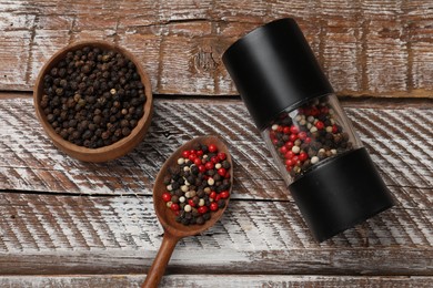 Photo of Different peppercorns on wooden table, flat lay