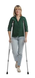 Full length portrait of woman with crutches on white background