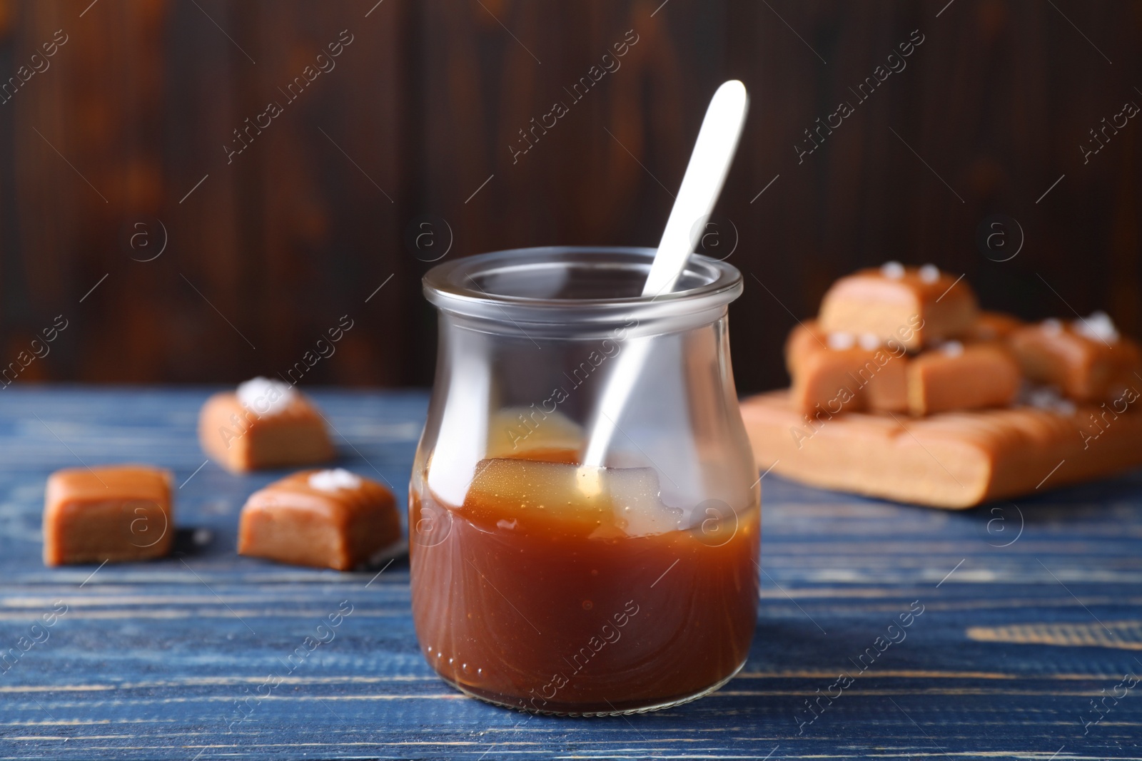 Photo of Salted caramel in jar on blue wooden table